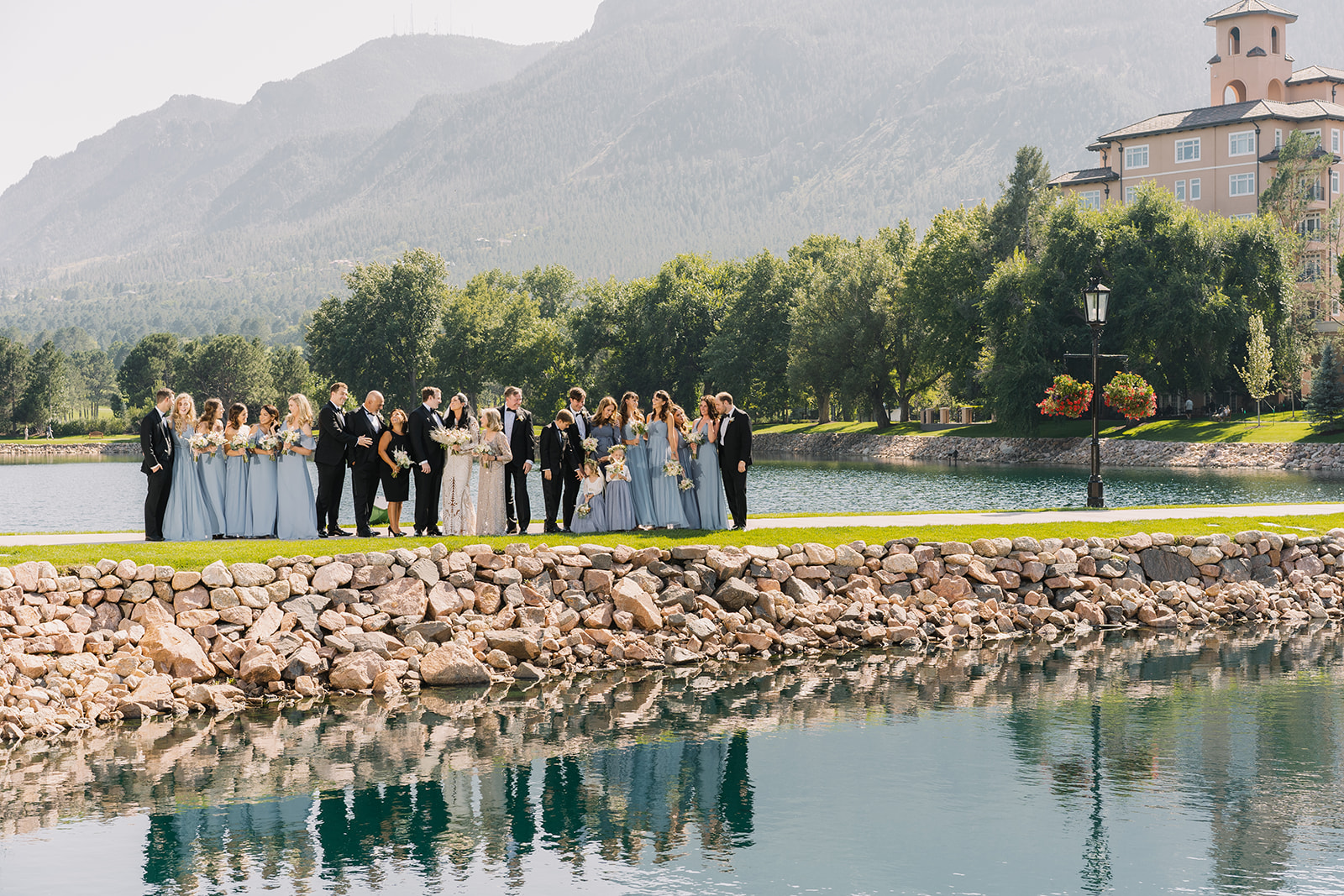 wedding party photo with mountain view and broadmoor in background