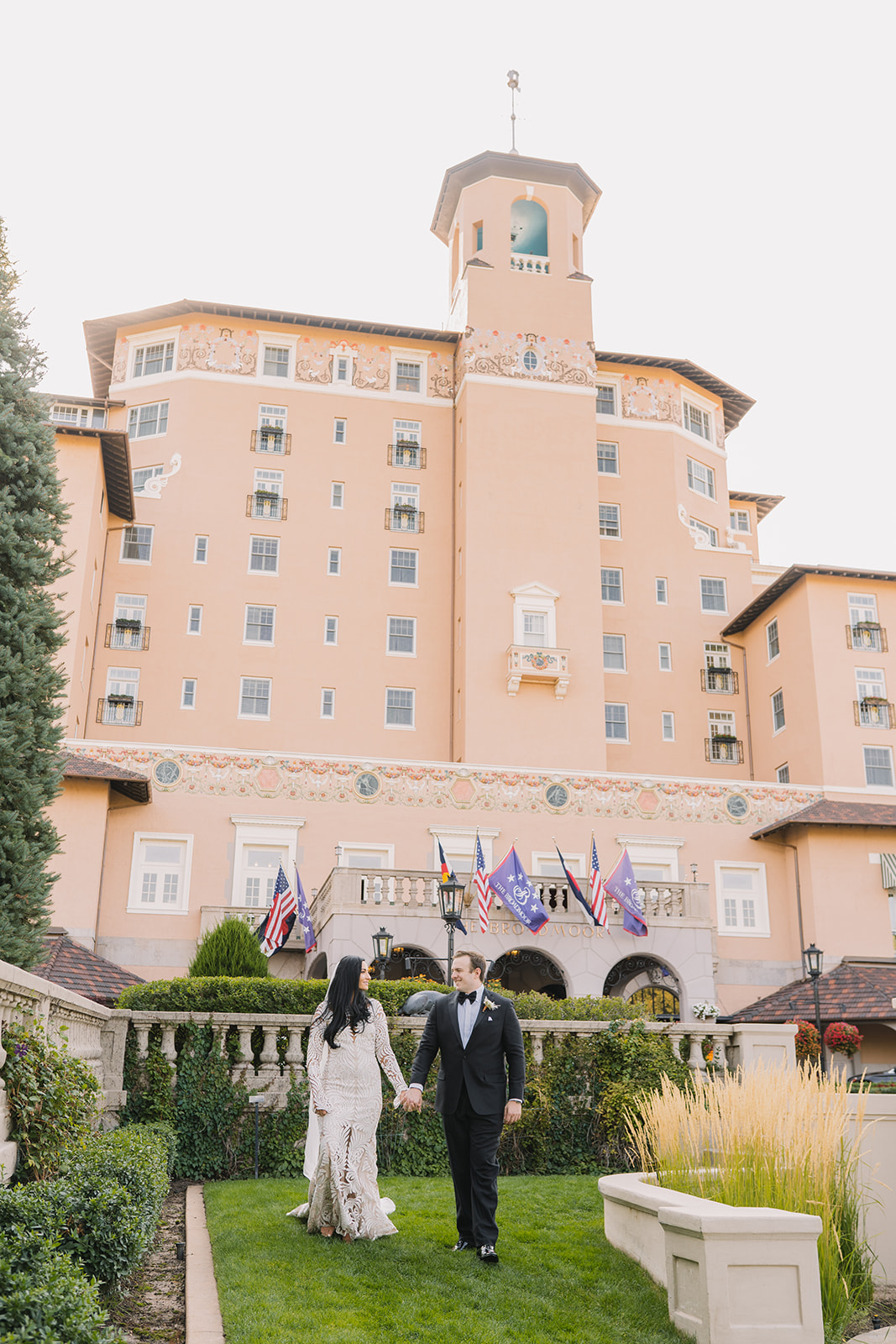 couple walking on front lawn of broadmoor on wedding day