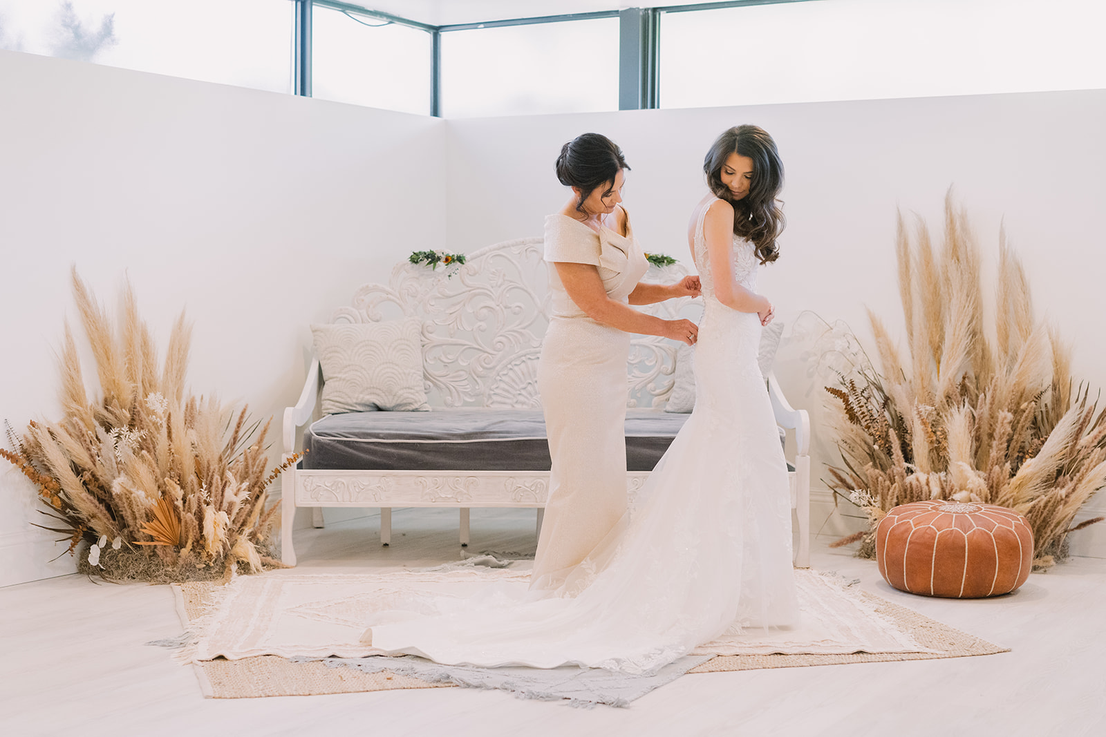 bride getting into wedding dress on her wedding day in bridal suite