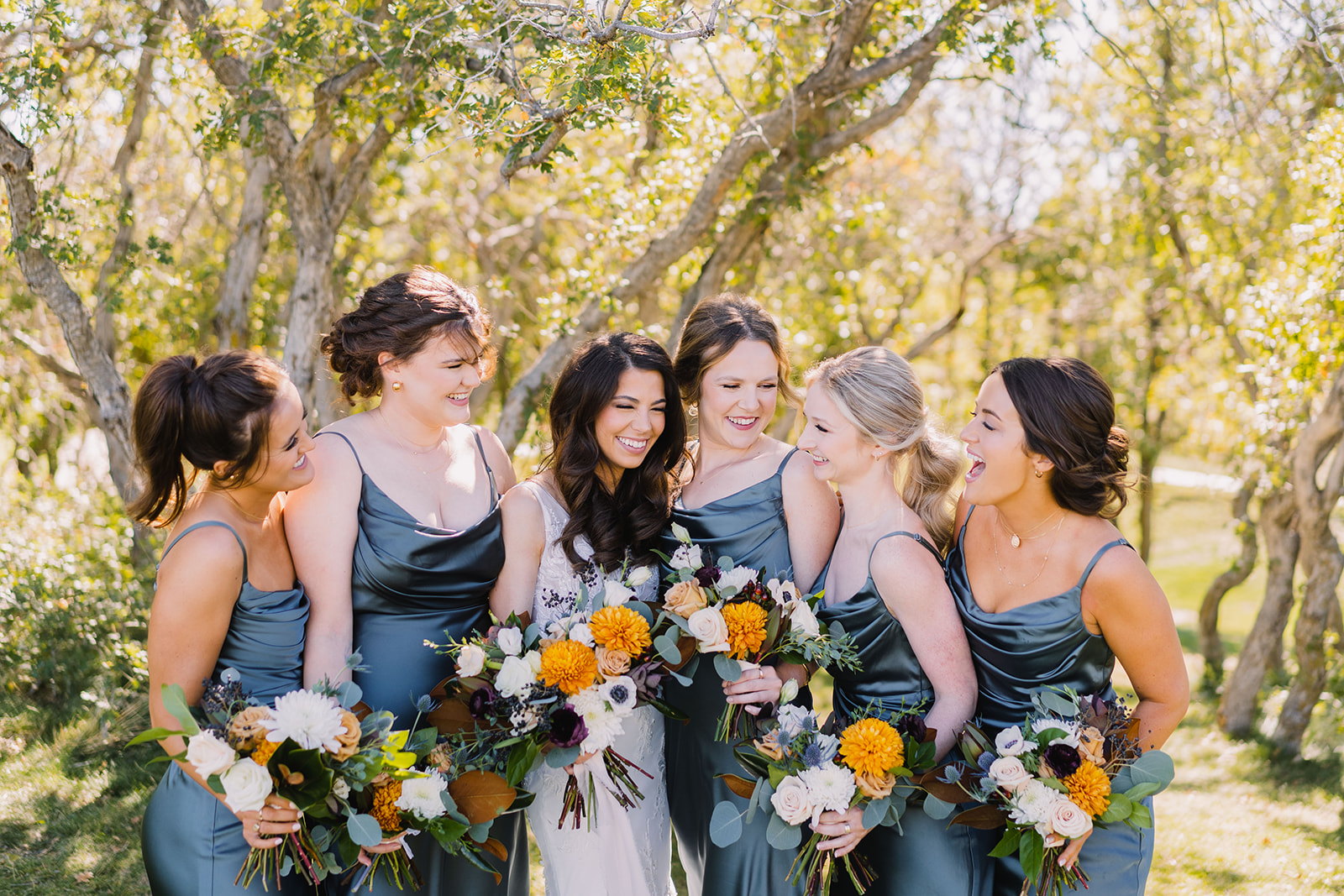 bridesmaids laughing together with the bride in fall