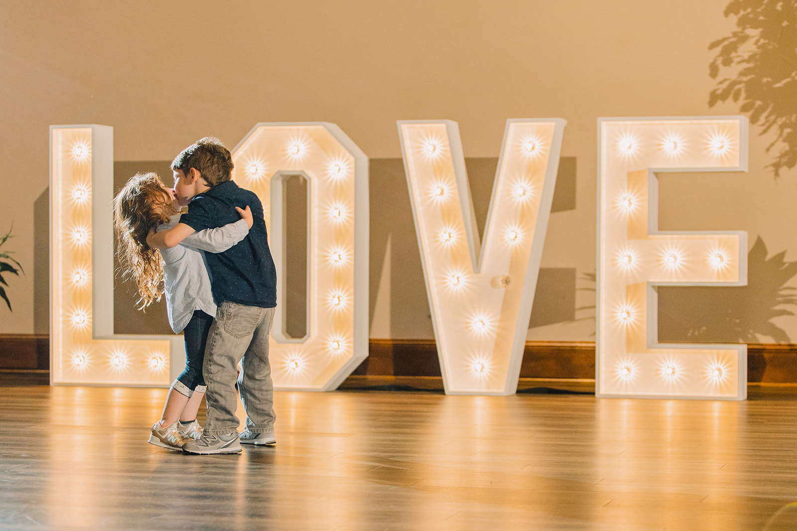 cute kids dancing at wedding reception in front of sign