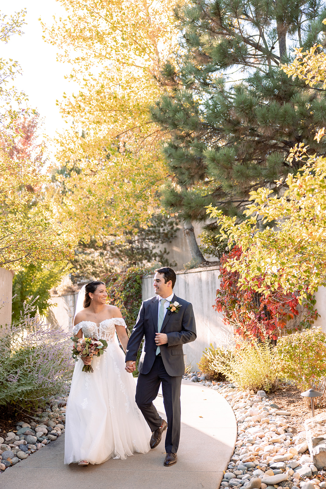 couple walking on path with fall leaves turning