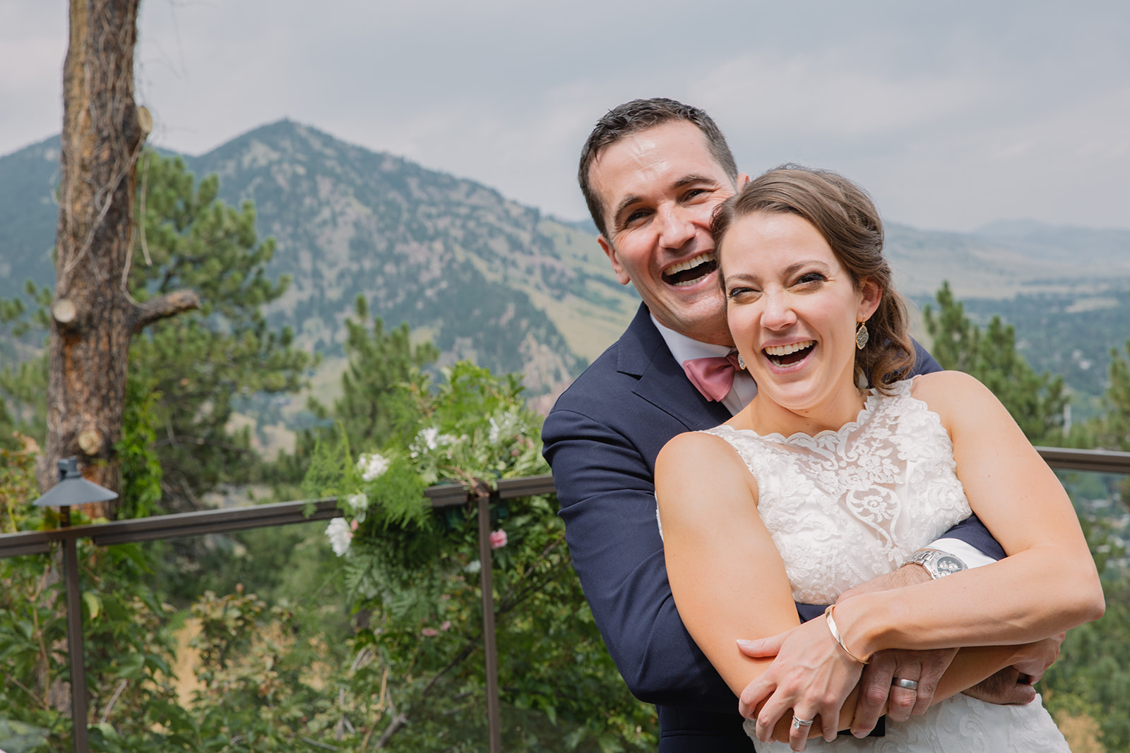 husband and wife smiles at flagstaff house with mountain view in the background
