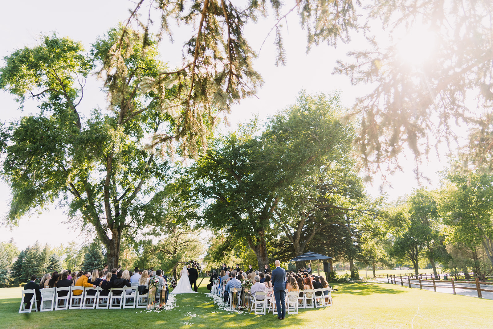 boulder country club wedding ceremony in summer with big trees
