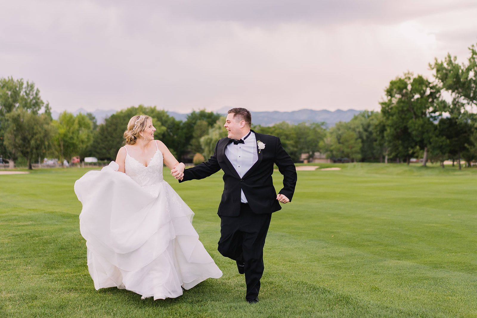 couple running back to reception during sunset photos on wedding day